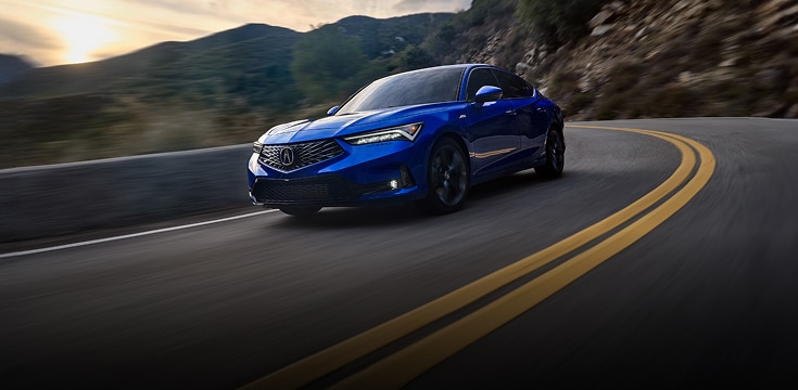 2024 Acura Integra A-Spec in Apex Blue Pearl front driving on a winding mountain road (Premium Sport Compact). 2024 Acura Integra A-Spec in Apex Blue Pearl front driving on a winding mountain road (Premium Sport Compact).